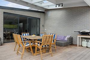 a wooden table and chairs on a patio at Tea Tree Pool Retreat in Inverloch