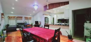 sala de estar con mesa roja y cocina en Bulla Villas & Suites, en Nadi International Airport