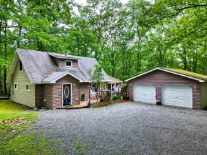 a house with a garage next to a driveway at 1mi to Lake Wallenpaupack | Firepit | Pet Friendly in Paupack