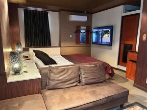 a bedroom with a bed and a couch and a tv at ウォーターゲート岐阜 A Japanese adult-oriented hotel in Gifu