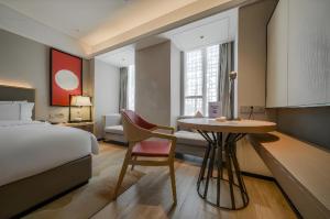 a hotel room with a bed and a desk with a chair at Echeng Hotel Nanning the Mixc Convention in Nanning +87 photos