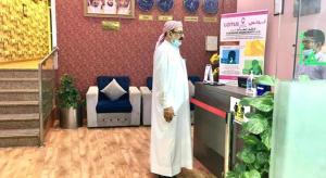 a man standing at a counter in a store at Lotus Furnished Hotel Apartments LLC. Ajman in Ajman 