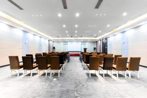a conference room with rows of chairs and a podium at Borrman Hotel Wuhan Hankou Railway Station Metro Station in Wuhan