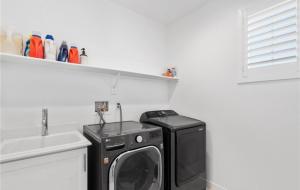 a kitchen with a washing machine and a sink at Rois Yucaipa in Yucaipa