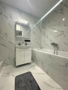 a white bathroom with a tub and a sink at Видові Апартаменти Residential GREAT ліфт, вода, тепло WiFi Працюють без світла in Kyiv +13 photos