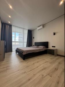 a bedroom with a bed and a large window at Видові Апартаменти Residential GREAT ліфт, вода, тепло WiFi Працюють без світла in Kyiv