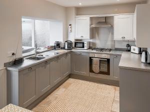 a kitchen with white cabinets and a sink at Walkers Retreat in Crook +12 photos