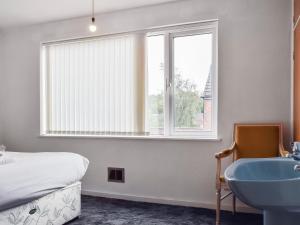 a bedroom with a bed and a sink and a window at Peacock House in Kenilworth