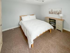 a bedroom with a bed with a nightstand and a bed sidx sidx sidx sidx at Riverside Cottage in Pinchbeck
