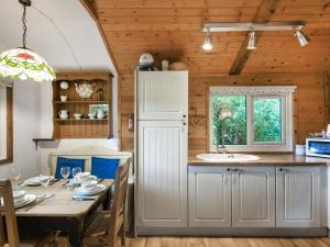 a kitchen and dining room with a table and a sink at The Owl's Nest - Uk50546 in Penegoes