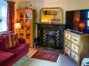 a living room with a fireplace and a red couch at Magnolia Cottage in Staunton