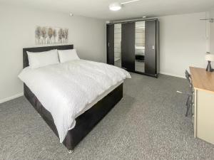 a bedroom with a large bed and a desk at Riverside Cottage in Pinchbeck +10 photos