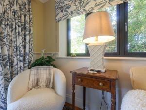 a living room with a chair and a lamp on a table at Brookside in Highway