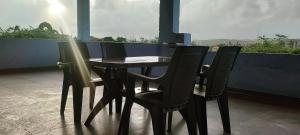 a black table and chairs on a balcony at Harekar Villa in Jalgaon