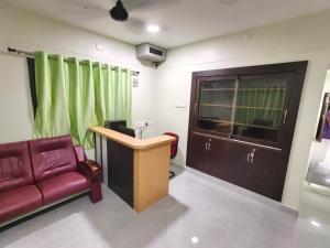 a office with a couch and a desk and a chair at CHETTINAD HOMESTAy in Chidambaram