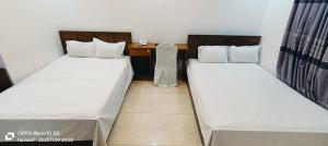 two twin beds in a room with a desk at Hotel D Palace in Faydābād