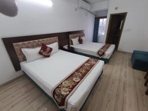 two beds in a room with two beds sidx sidx sidx sidx at Hotel D Palace in Faydābād