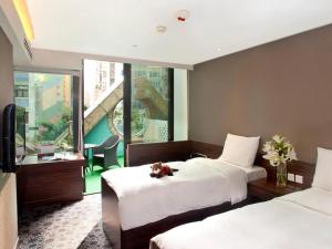 a bedroom with two beds with a teddy bear sitting on the bed at J Link Hotel in Hong Kong