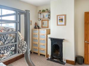 a bedroom with a fireplace and a bed at Miner's Rest in Rowrah +3 photos