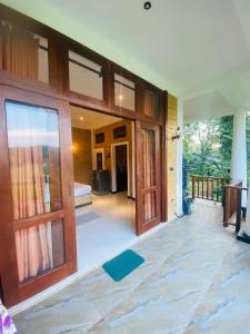an entry to a house with wooden doors at Rosie Breeze in Talpe