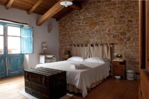 a bedroom with a bed and a stone wall at Domu Antiga in Gergei +43 photos