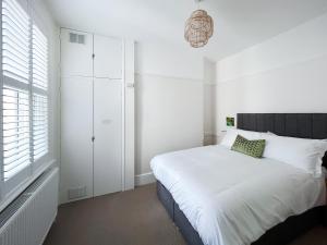 a white bedroom with a bed and a window at Pebble Hideaway - Uk50551 in Worthing