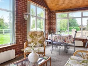 a room with a table and chairs and windows at Quail Cottage - Uk50659 in Little Singleton