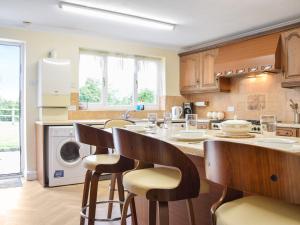 a kitchen with a table and some chairs in it at Quail Cottage - Uk50659 in Little Singleton