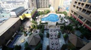 an overhead view of a courtyard with a pool in a city at Babylon Hotel in Dongguan