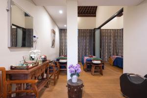 a room with a table and chairs and a bedroom at Aldeoz Grand Kancana Villas Resort Bali in Kerobokan