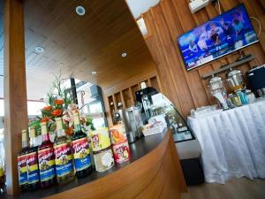 a bar with a counter with bottles of alcohol at GT Residence Hotel in Buriram