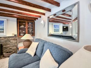 圣莫斯Fuchsia Cottage的客厅配有蓝色的沙发和大镜子