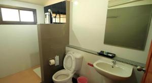 a bathroom with a toilet and a sink at So Herbs at Home in Chiang Rai