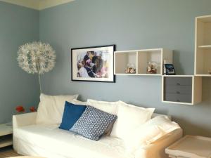 een woonkamer met een witte bank met een foto aan de muur bij Belvilla by OYO Casa Marina a Ghiffa in Ghiffa