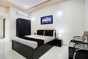 カルヌールにあるHotel O Kurnool Bus Stand Formerly RR Residencyのベッドルーム(白黒のベッド1台、椅子付)