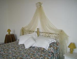a bedroom with a bed with a canopy and pillows at Le Finestre di San Michele in Castiglion Fiorentino