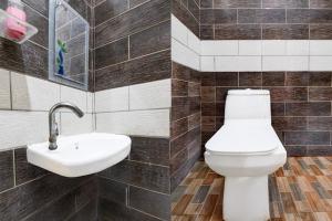 a bathroom with a toilet and a sink at Hotel O Rajaram Singh Blessing Garden And Hotel in Prayagraj