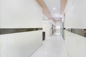 カルヌールにあるHotel O Kurnool Bus Stand Formerly RR Residencyの白いタイルの床と壁がある病院の廊下