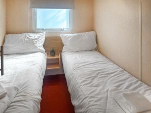 two beds in a small room with a window at Emerald Pines - Uk50577 in Blanchland