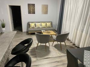 a living room with a couch and chairs and a table at Fo-Rest Apartman in Nyíregyháza
