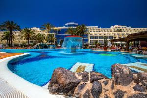 a large swimming pool with a fountain in front of a hotel at SBH Costa Calma Palace Thalasso & Spa in Costa Calma