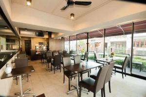 a dining room with tables and chairs and windows at Wsotel Hotel in Songkhla