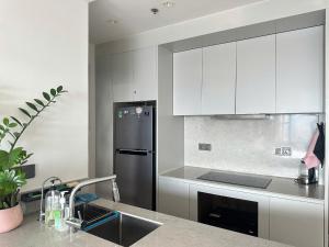 a kitchen with white cabinets and a stainless steel refrigerator at Rivergate Residence Central in Ho Chi Minh City