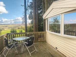 a patio with a table and chairs on a deck at Emerald Pines - Uk50577 in Blanchland