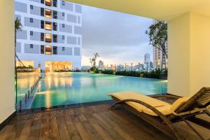 a swimming pool with a chair and a building at Rivergate Residence Central in Ho Chi Minh City