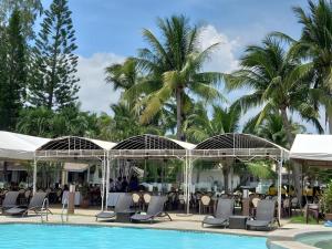a pool at a resort with chairs and palm trees at Lago de Oro in Batangas City