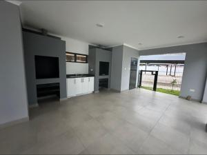 a large empty living room with a television and a large room at EchoPheme Suites in Gaborone