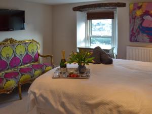 un letto con vassoio di cibo e una bottiglia di champagne di Samphire Cottage a Brixham