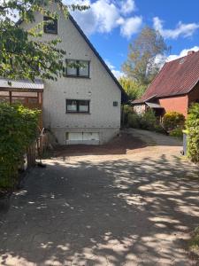 a white brick house with a driveway in front of it at Terrassenwohnung im Alstertal in Hamburg