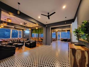 a living room with leather furniture and a ceiling fan at Alchemy Bistro and Inn, Dharamshala in Dharmsala